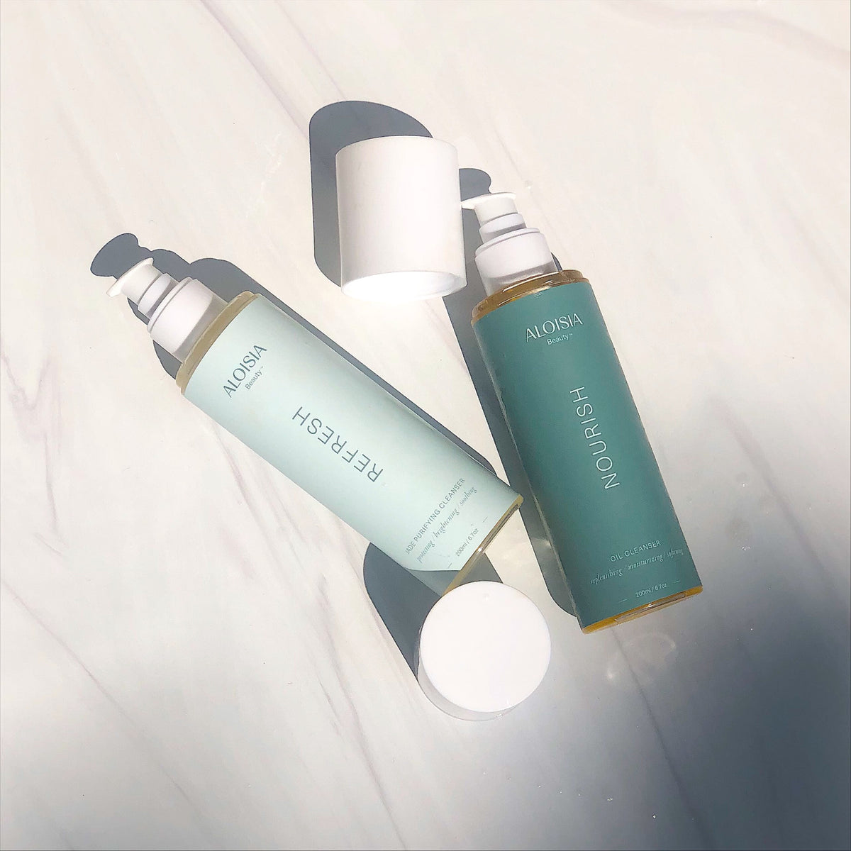 Two skincare bottles labeled 'Refresh' and 'Nourish' on a light background