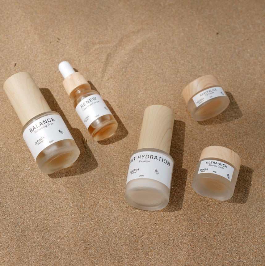 ANTI-AGING & BRIGHTENING MINI Set bottles and jars arranged on sand