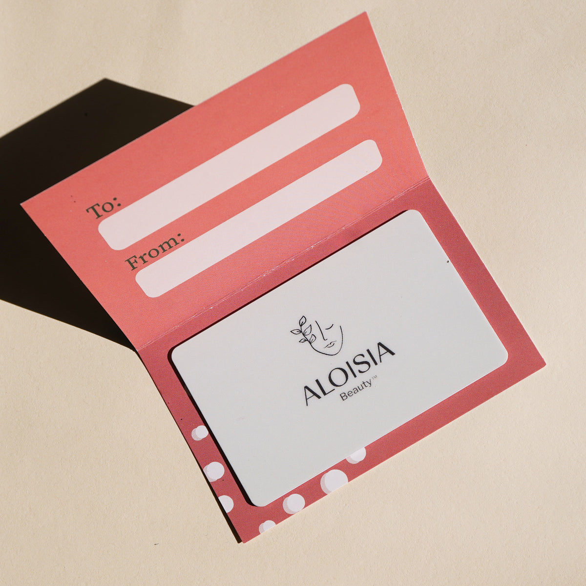 Aloisia Beauty digital gift card in a coral holder