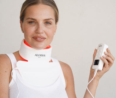 Woman wearing the REFINING LED neck panel and holding the controller