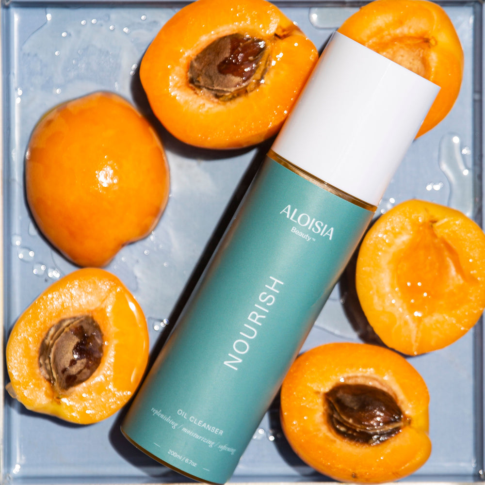NOURISH Oil Cleanser surrounded by Apricots